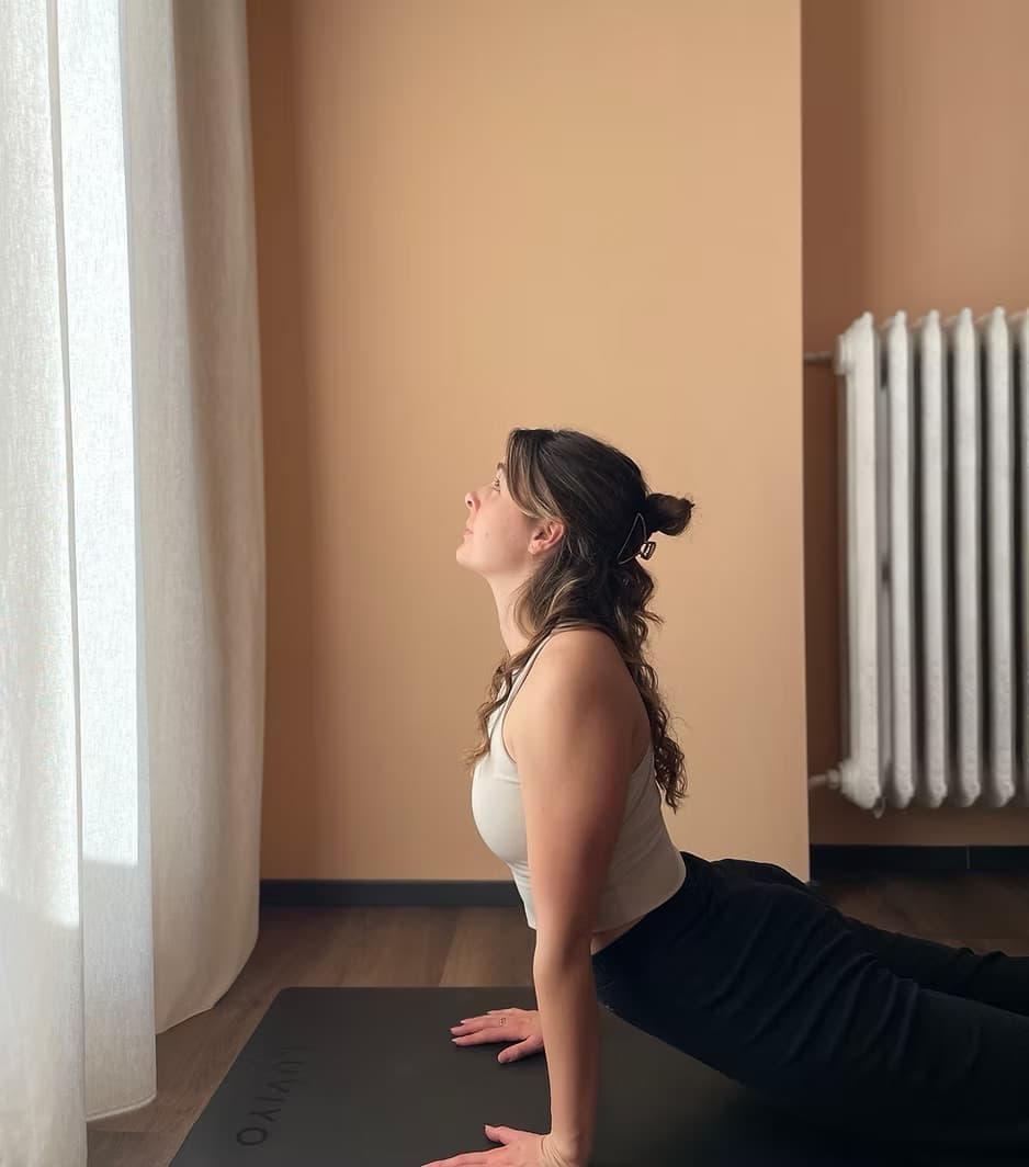 Noemie in einer Yoga Kobra-Pose am Fenster